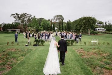 Bride and groom walking down the aisle at an outdoor wedding ceremony.