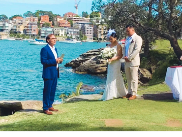 Couple standing by the water during an outdoor wedding ceremony.