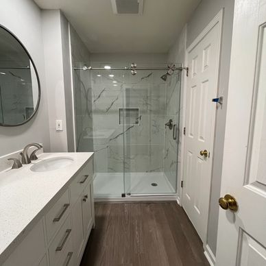 Modern bathroom with glass shower and white vanity.