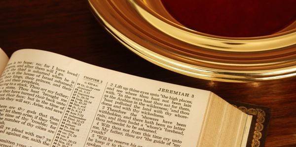 Open Bible showing Jeremiah 3 near a gold communion plate.
