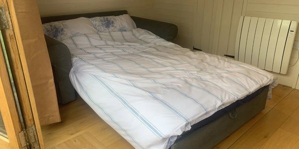 Sofabed inside glamping pod near Builth Wells, Powys – cosy riverside stay for couples in Wales