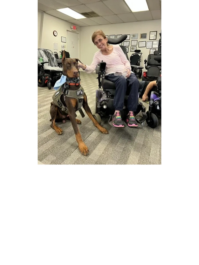 Mikki in power chair with therapy dog
