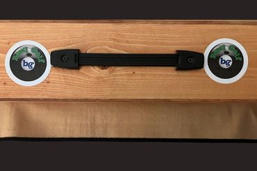 Wooden surface with two golf ball markers and a black handle.