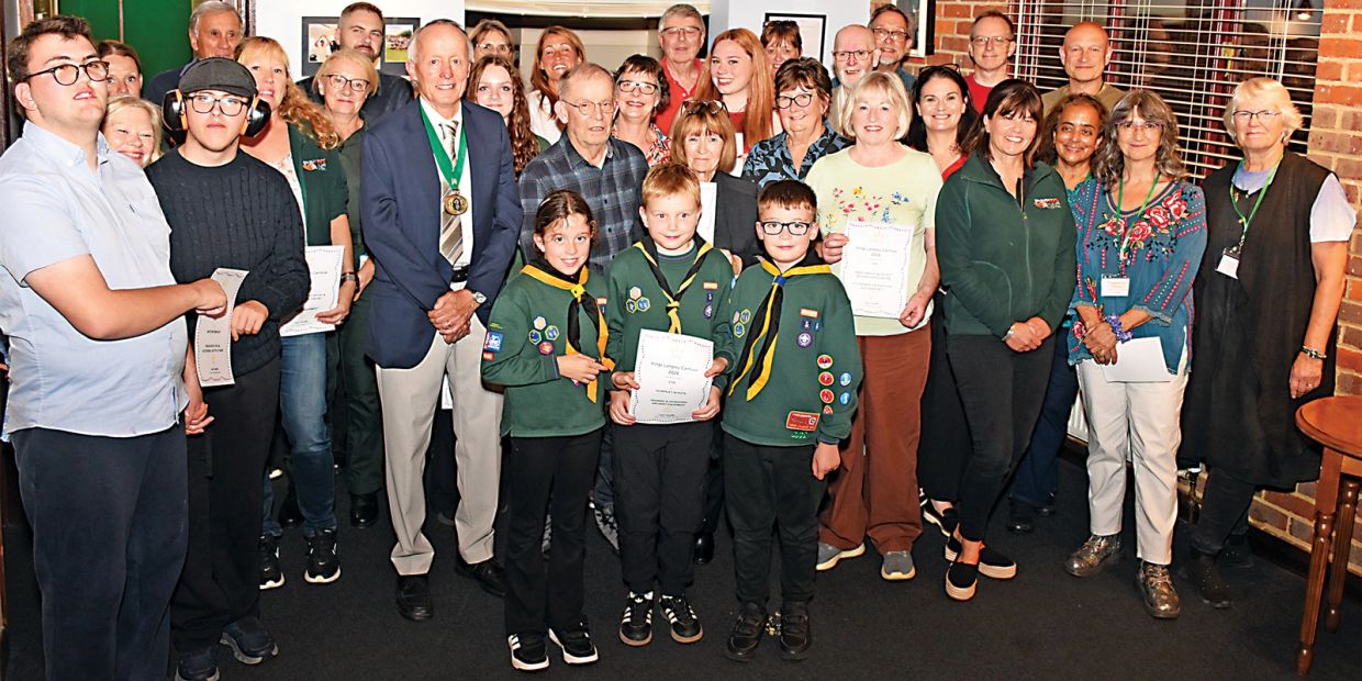 Group photo of people holding certificates, including children in scout uniforms.