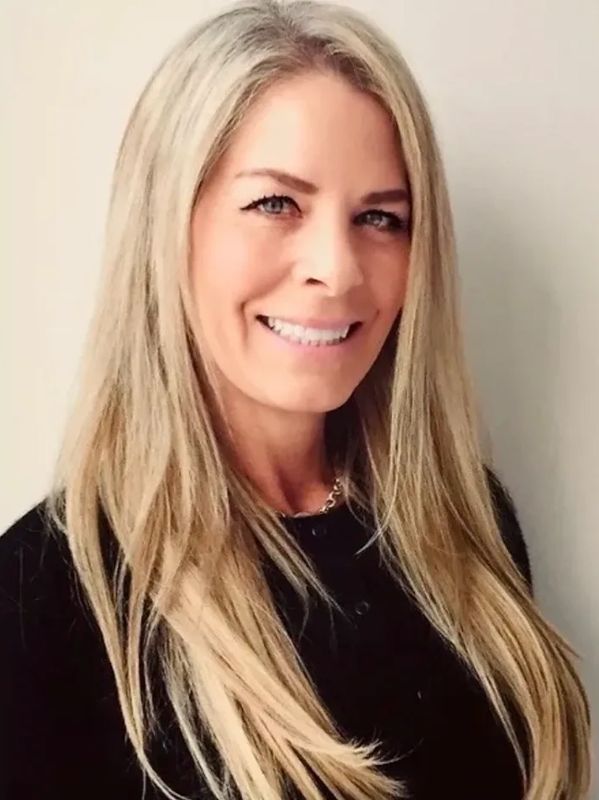 Smiling woman with long blonde hair in black top.