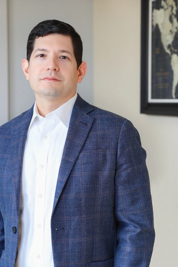 Professional man in a blue suit jacket and white shirt.
