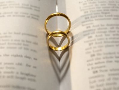 Two wedding Ring on the bible with shadow of heart shape on the page