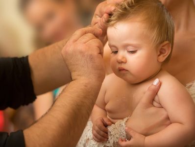 Newborn baby water baptism ritual. Christian orthodox baptism in Greece.