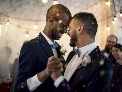 Closeup of newly married gay couple dancing at wedding celebration