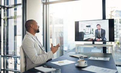 Businessman at desk having a virtual meeting