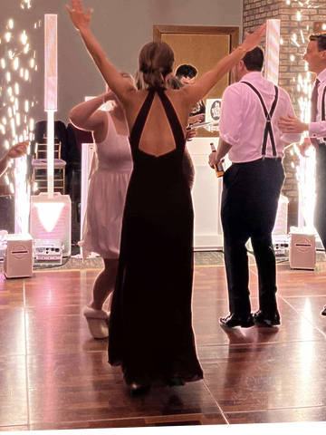 Cold sparkler machine effects during a wedding. Woman with arms extended having a blast!