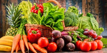 A colorful assortment of fresh fruits and vegetables on a wooden surface.