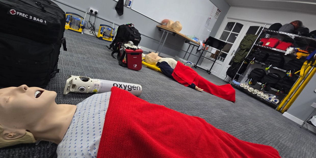 Medical training dummies with oxygen tanks and red blankets.