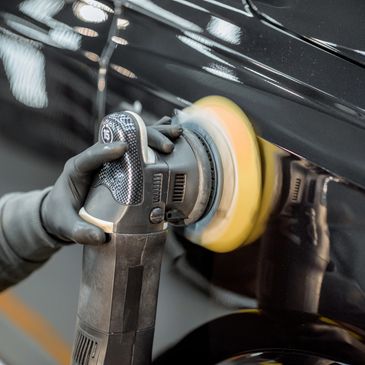 "Professional auto polishing on a vehicle’s surface enhancing shine and removing fine scratches"