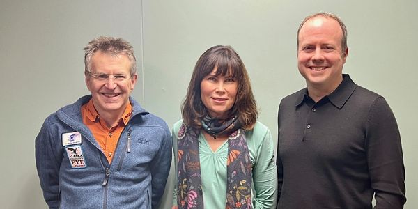 Three people standing and smiling at the camera.