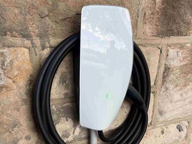 Electric vehicle charger mounted on a stone wall.