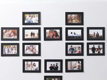 A heart-shaped photo collage on a wall with various family and couple pictures.
