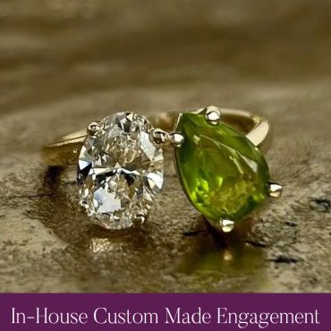 Finished custom two-stone engagement ring with diamond and green gemstone.