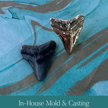 Natural shark tooth beside a newly cast metal copy.