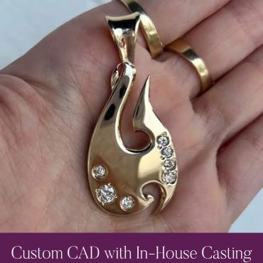 Finished custom gold fishhook pendant with diamond accents.