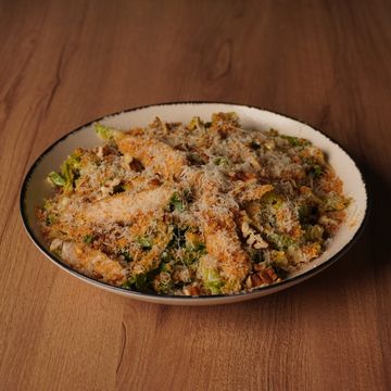A bowl of crispy breaded vegetable strips topped with grated cheese.