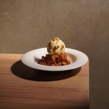 A dessert with ice cream and caramel sauce on a wooden table.