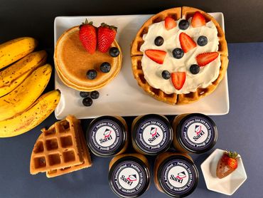 Desayuno con pancakes, banano y fresas junto a crema de maní Sand (vista superior)