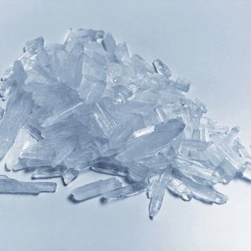 Close-up of translucent crystalline shards on a white surface.