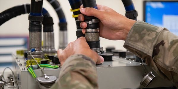 Soldier handling military equipment cables.