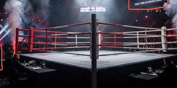 An empty boxing ring at a sports gala with audience and officials around.