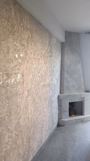 Decorative textured wall and modern fireplace with patterned tiles.