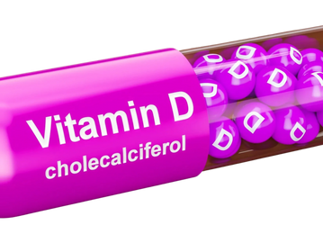 Close-up of a Vitamin D capsule with purple pellets inside.