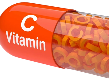 A large capsule labeled Vitamin C filled with orange letter C shapes.