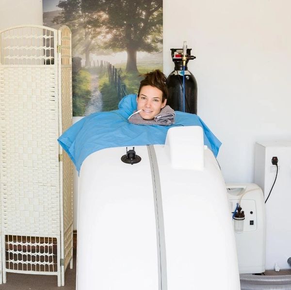 Woman enjoying a therapy session inside a wellness capsule.