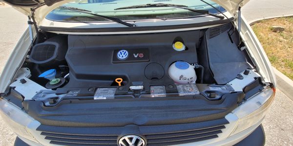 Open hood showing Volkswagen V6 engine compartment with clean components.