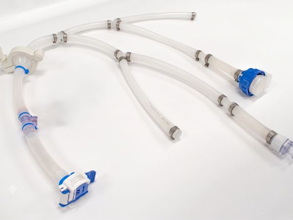 Medical tubing with blue connectors on a white surface.