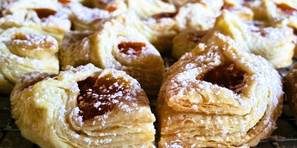 Close-up of flaky pastries dusted with powdered sugar.