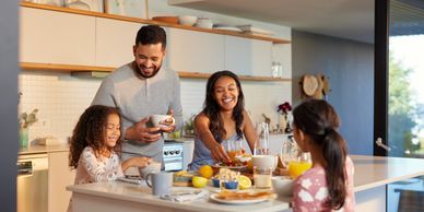 Family enjoying breakfast together in a bright modern kitchen.
