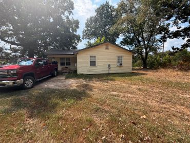 Single-story house with red truck parked outside.