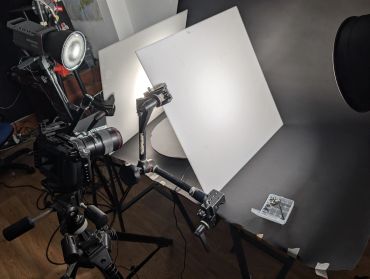Camera and lighting setup with white boards.