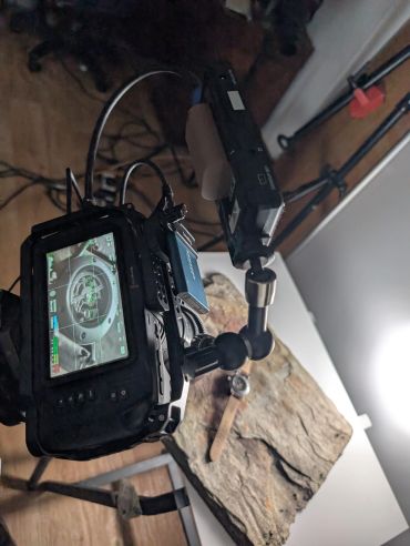Camera filming a wristwatch on rock.