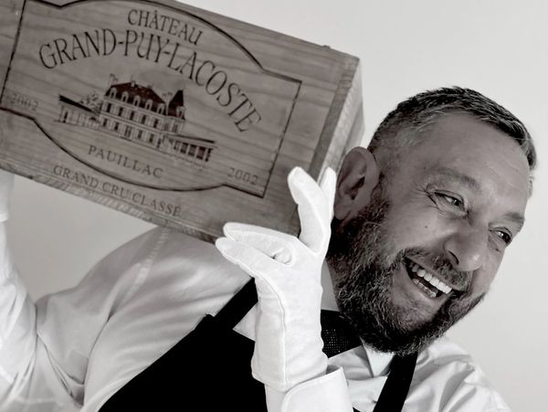 White glove service holding a case of Pauillac