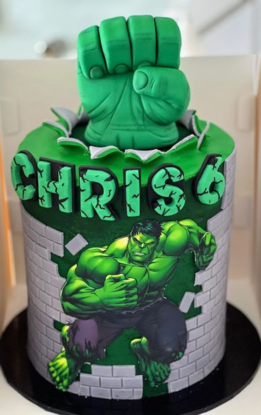 A Hulk-themed birthday cake with a green fist topper and name "Chris 6".