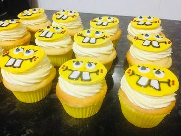Cupcakes topped with SpongeBob-themed edible decorations and white frosting.