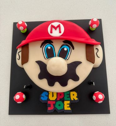 A cake designed as Mario's face with 'Super Joe' text.