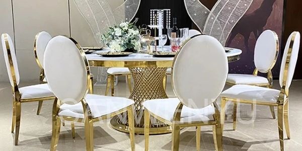 Elegant white marble table 
Cushion chair in gold color 
And variety of center pieces