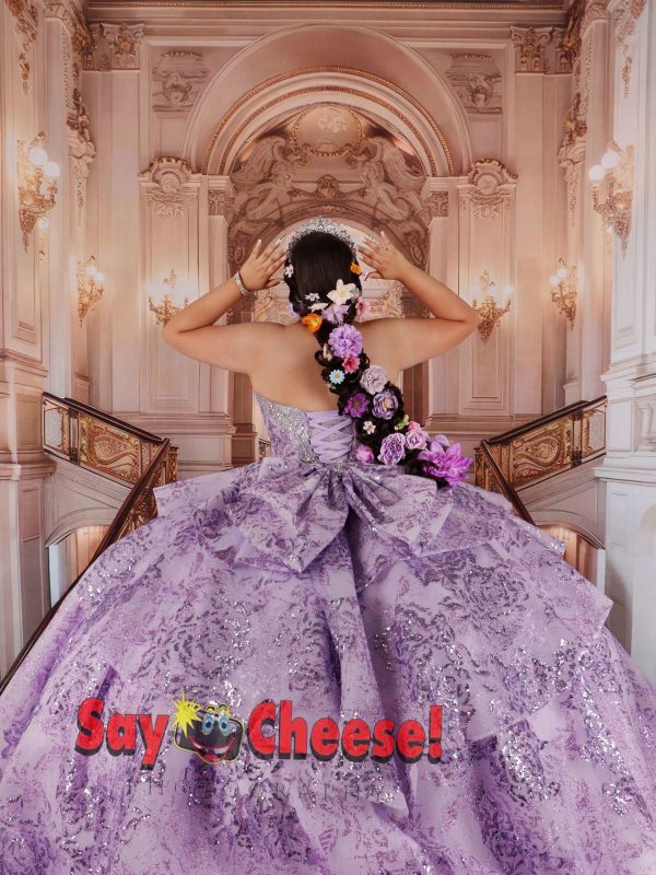 Woman in elegant purple gown with floral hair decoration.