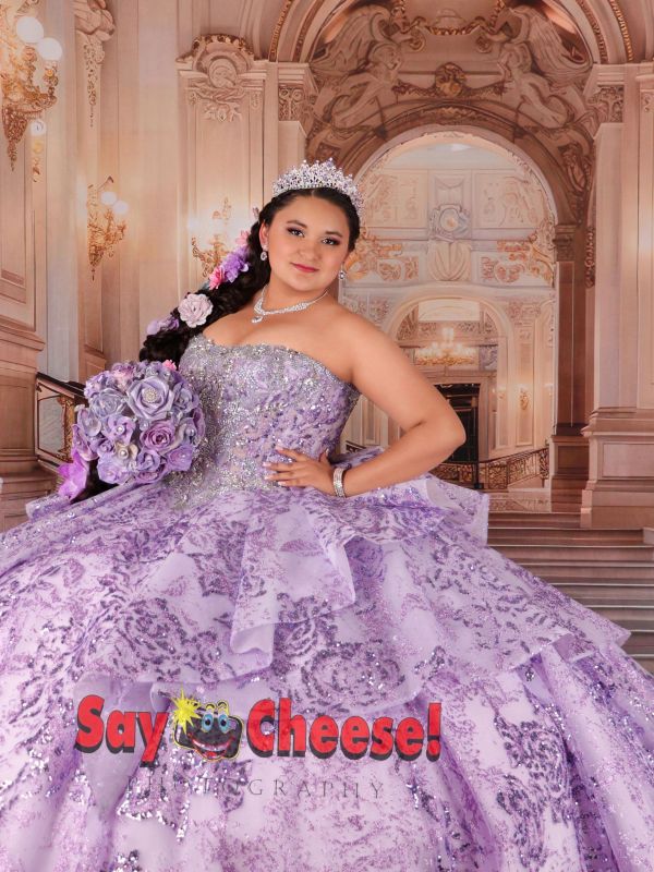 Young woman in elegant purple gown poses with bouquet.