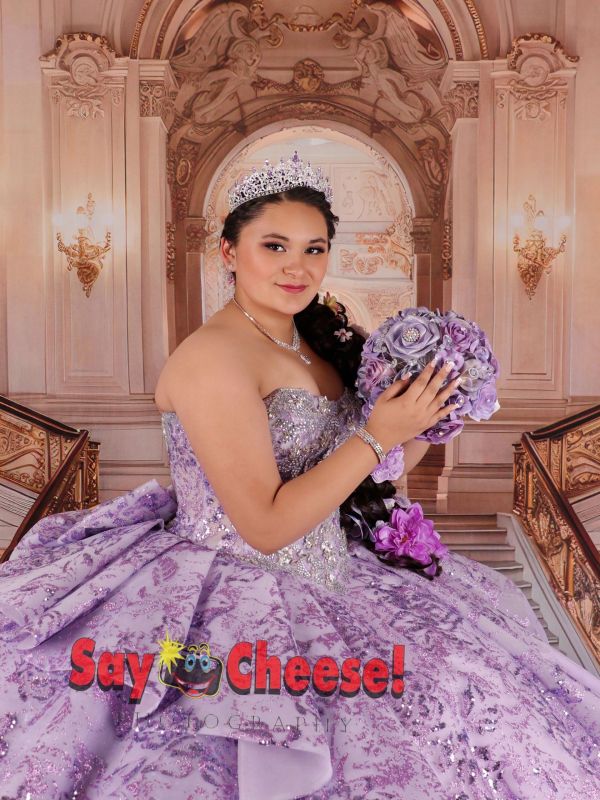 Young woman in purple quinceañera dress with tiara and bouquet.