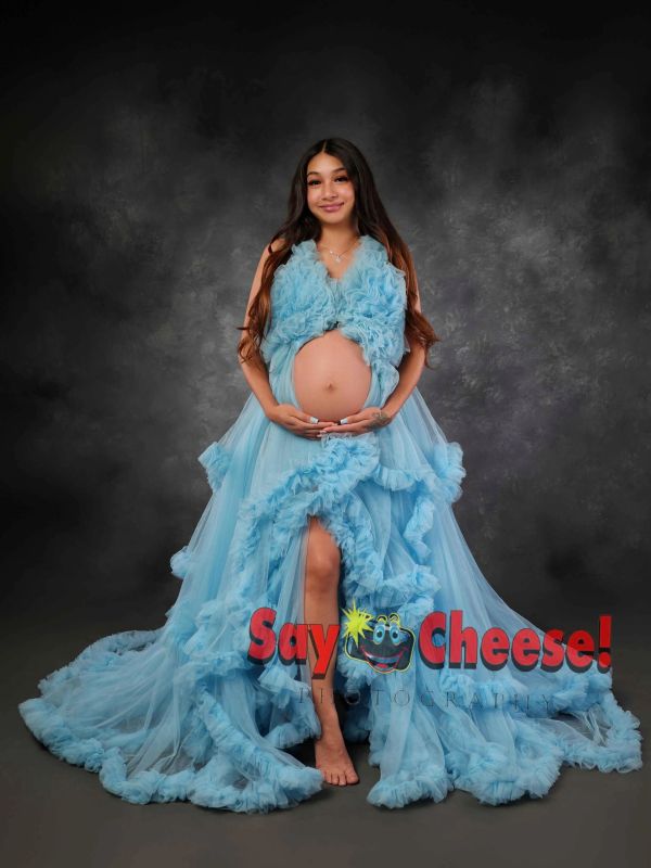 Pregnant woman in a flowing blue dress posing.